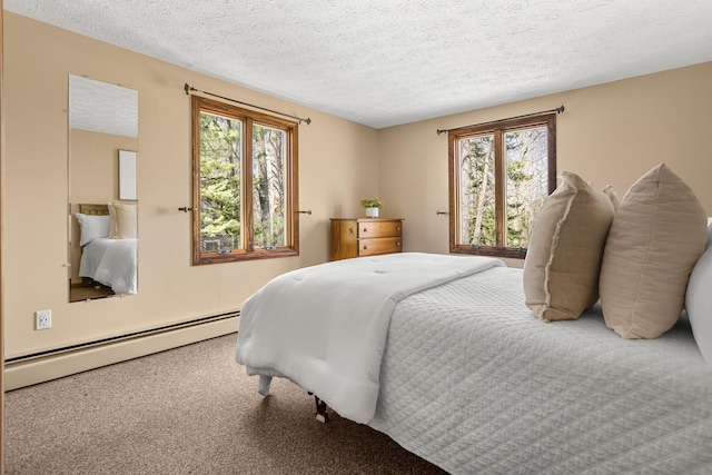 carpeted bedroom with a textured ceiling and a baseboard heating unit