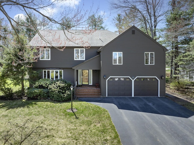 view of front of property featuring a garage, aphalt driveway, and a front yard