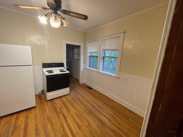kitchen with freestanding refrigerator, electric range, wainscoting, hardwood / wood-style flooring, and a ceiling fan