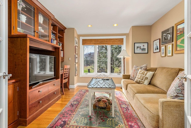 living area featuring recessed lighting, light wood finished floors, and baseboards