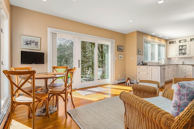 interior space featuring recessed lighting, light wood finished floors, a baseboard heating unit, and a healthy amount of sunlight