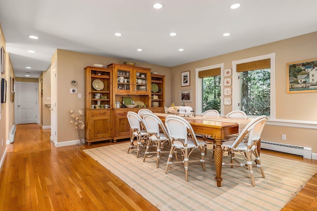 dining room featuring baseboards, a baseboard radiator, light wood finished floors, and recessed lighting