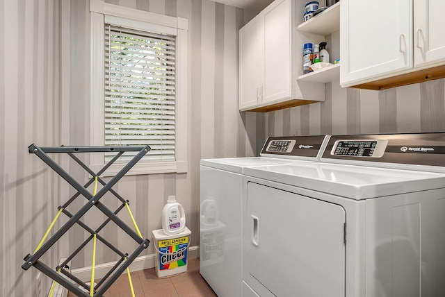 laundry area featuring baseboards, cabinet space, wallpapered walls, and independent washer and dryer