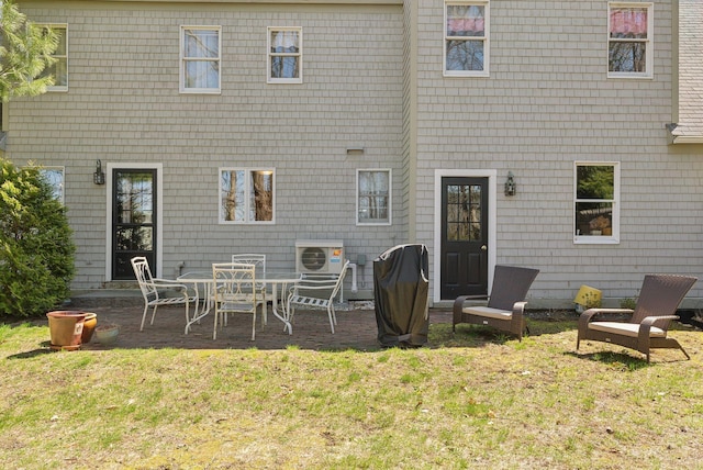 rear view of house featuring a lawn and a patio