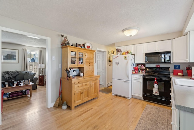 kitchen featuring a textured ceiling, light wood-type flooring, light countertops, white cabinets, and black appliances