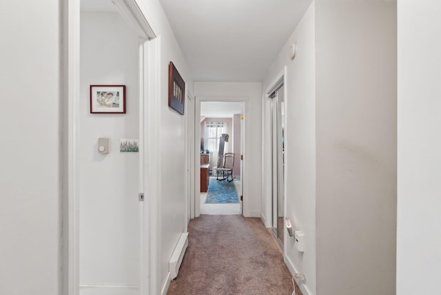 corridor with baseboards and carpet flooring