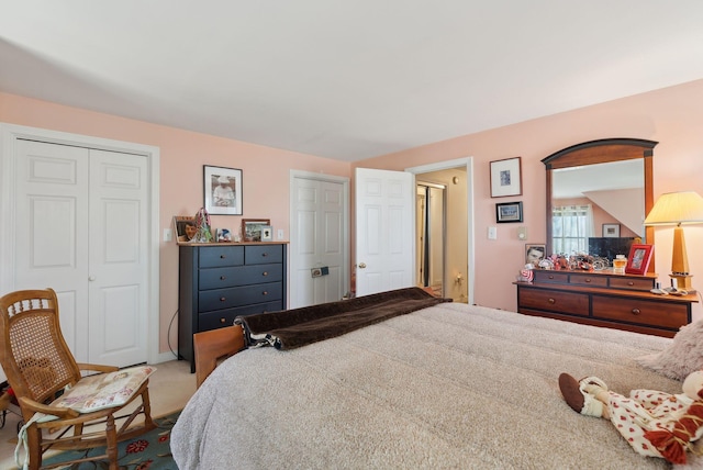 carpeted bedroom with two closets and baseboards