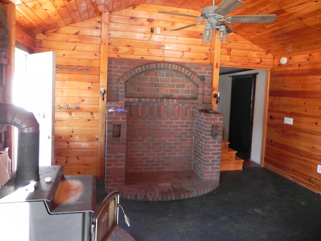 interior space featuring wooden walls, wooden ceiling, ceiling fan, and lofted ceiling