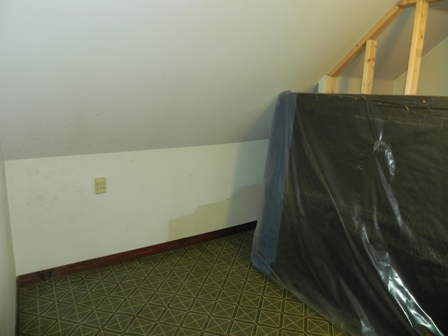 additional living space with tile patterned floors and lofted ceiling
