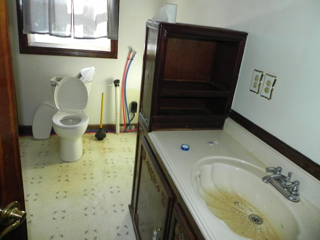 bathroom featuring vanity, baseboards, tile patterned floors, and toilet
