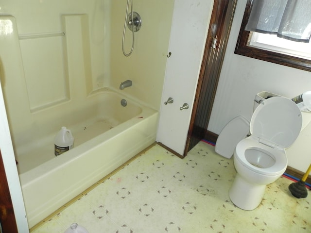 bathroom featuring toilet, tile patterned floors, tub / shower combination, and baseboards