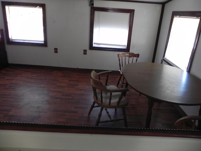 dining space with baseboards and wood finished floors