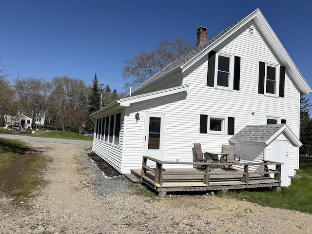 30 Mill St, Harrington, ME 04643 - back of property featuring a deck, a shed, a chimney, an outbuilding, and a shingled roof