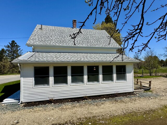 30 Mill St, Harrington, ME 04643 - view of home's exterior featuring roof with shingles and a chimney