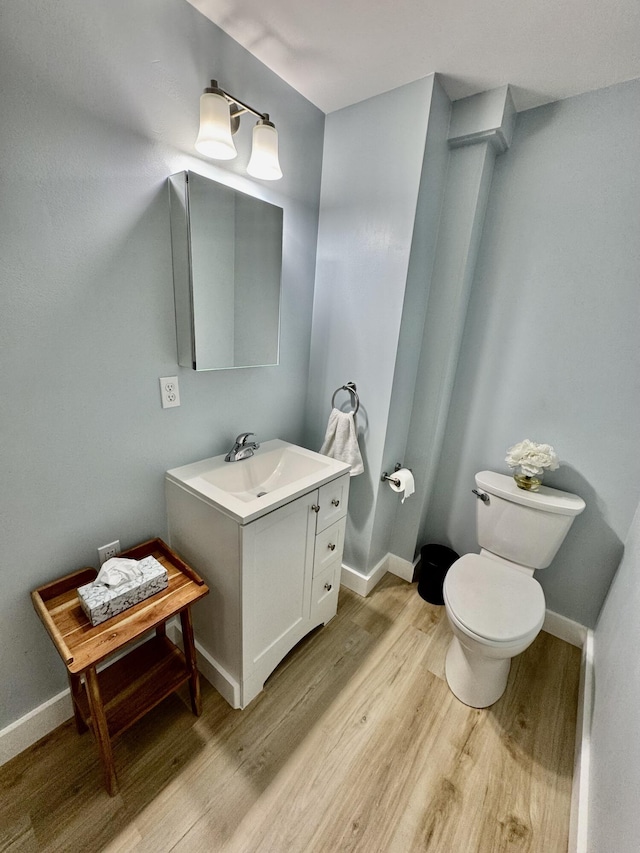 30 Mill St, Harrington, ME 04643 - bathroom with wood finished floors, toilet, vanity, and baseboards