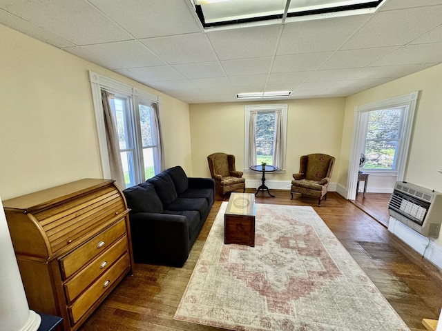 30 Mill St, Harrington, ME 04643 - living area with heating unit, dark wood-style flooring, healthy amount of natural light, a drop ceiling, and baseboards