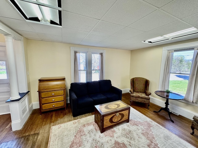 30 Mill St, Harrington, ME 04643 - living room featuring decorative columns, a drop ceiling, wood finished floors, and baseboards