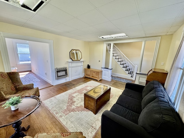 30 Mill St, Harrington, ME 04643 - living area featuring heating unit, stairway, wood finished floors, baseboards, and a drop ceiling