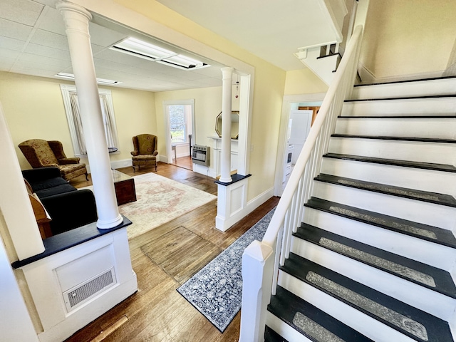 30 Mill St, Harrington, ME 04643 - stairway featuring decorative columns, wood finished floors, and baseboards