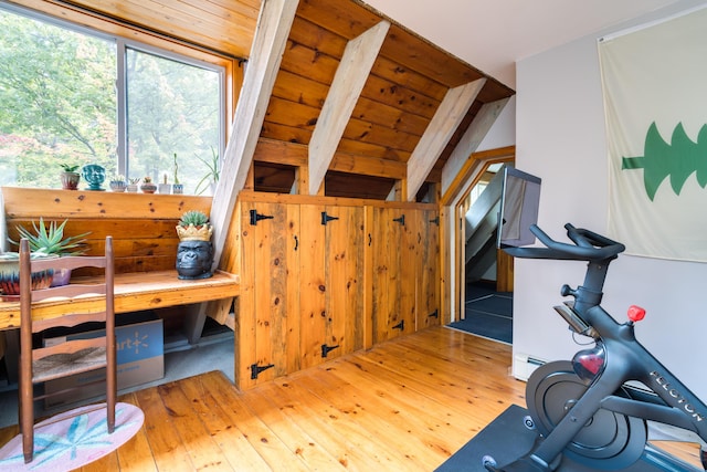 interior space featuring wood walls, a baseboard radiator, and hardwood / wood-style flooring