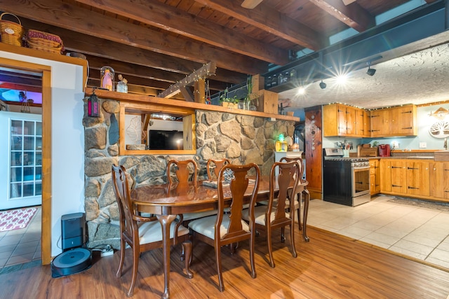 dining area with wood ceiling, beamed ceiling, and light tile patterned floors
