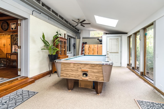 playroom featuring a ceiling fan, baseboards, light colored carpet, vaulted ceiling with skylight, and billiards