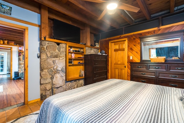 bedroom featuring wood walls, wooden ceiling, beam ceiling, and tile patterned flooring