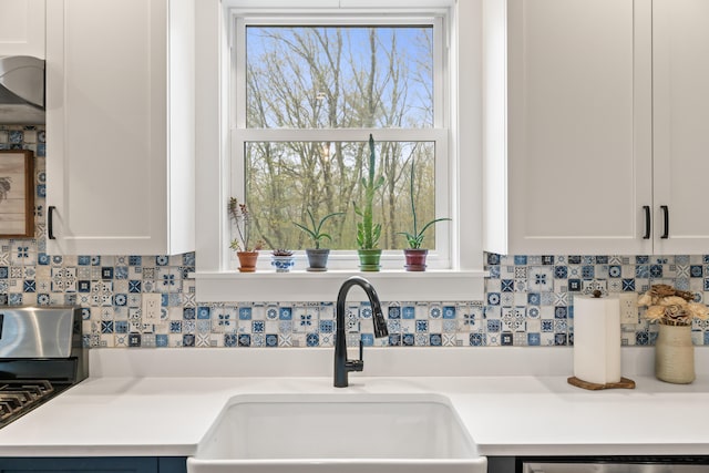 29 Hawks Nest Ln, Wells, ME 04090 - kitchen view of a sink, tasteful backsplash, stainless steel dishwasher, white cabinets, and light countertops