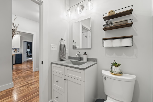 29 Hawks Nest Ln, Wells, ME 04090 - half bathroom with wood finished floors, vanity, toilet, and baseboards
