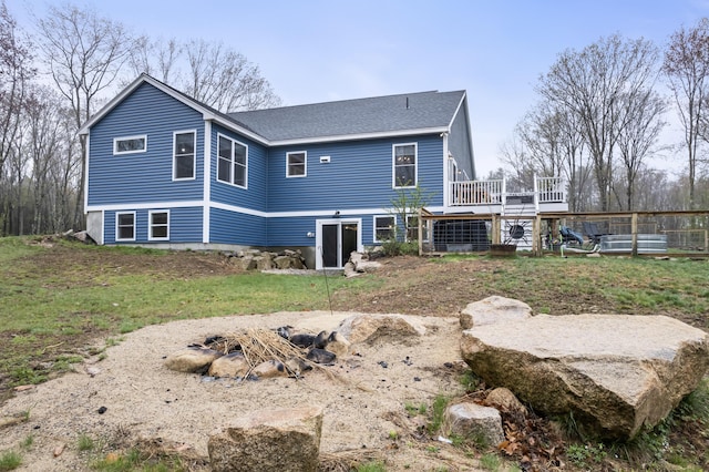 29 Hawks Nest Ln, Wells, ME 04090 - rear view of house featuring a wooden deck, a shingled roof, an outdoor fire pit, and fence