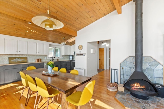 1588 Turtle Head Rd, Islesboro, ME 04848 - dining room featuring wooden ceiling, light wood finished floors, a wood stove, and high vaulted ceiling