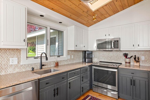 1588 Turtle Head Rd, Islesboro, ME 04848 - kitchen with stainless steel appliances, a sink, vaulted ceiling, gray cabinets, and white cabinetry