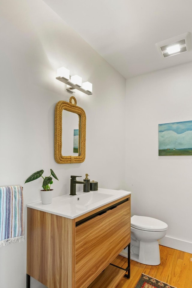 1588 Turtle Head Rd, Islesboro, ME 04848 - half bath featuring vanity, toilet, wood finished floors, and baseboards
