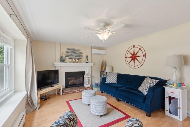 48 Woodside Dr, Kennebunk, ME 04043 - living area featuring a wall mounted AC, a baseboard radiator, light wood-style floors, and a ceiling fan