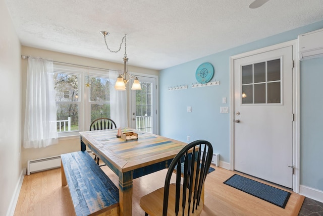 48 Woodside Dr, Kennebunk, ME 04043 - dining area with a baseboard heating unit, a textured ceiling, a wall unit AC, light wood-style floors, and baseboards
