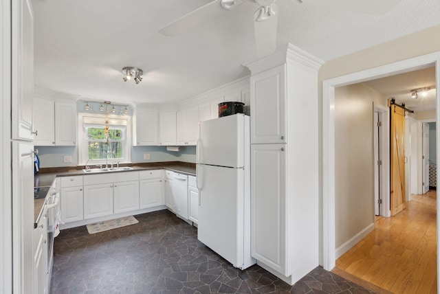 48 Woodside Dr, Kennebunk, ME 04043 - kitchen with white appliances, a sink, a barn door, dark countertops, and white cabinets