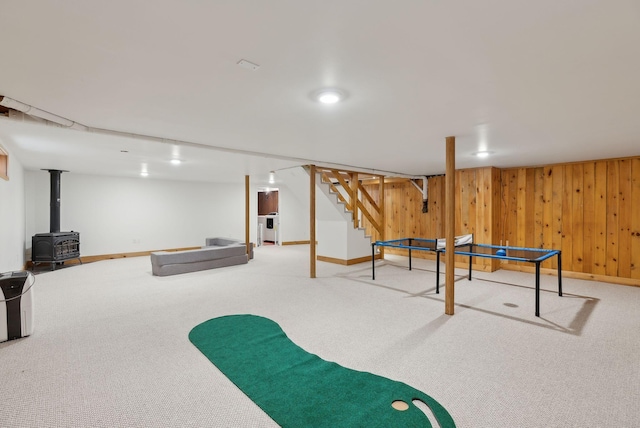 48 Woodside Dr, Kennebunk, ME 04043 - playroom with a wood stove, carpet, baseboards, and wood walls