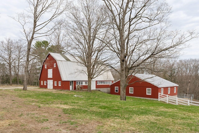 view of yard with a barn, fence, and an outbuilding
