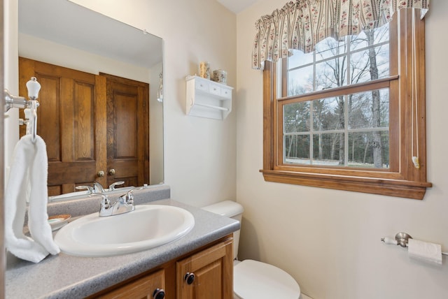 half bathroom featuring vanity and toilet