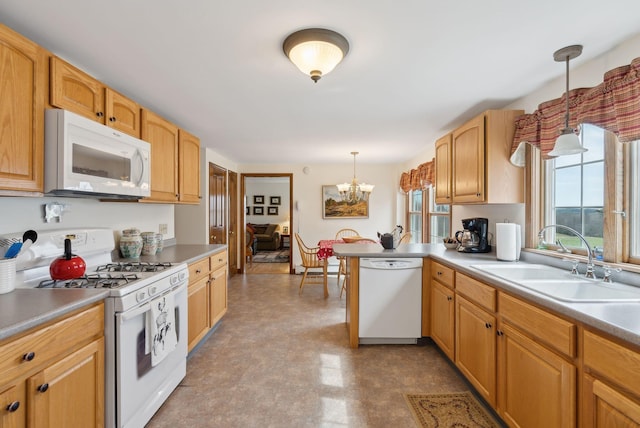 kitchen with pendant lighting, white appliances, tile patterned floors, a sink, and a notable chandelier