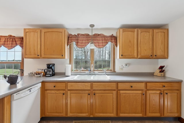 kitchen with light countertops, white dishwasher, pendant lighting, and a sink