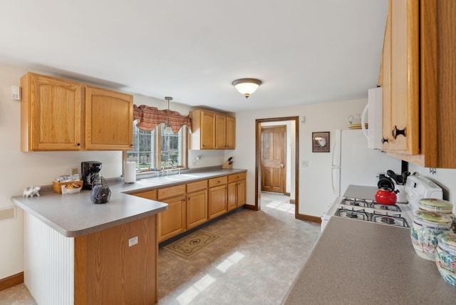 kitchen featuring a sink, white appliances, a peninsula, baseboards, and light floors