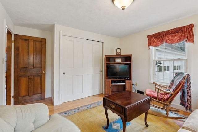 living area featuring light wood-style floors and baseboards