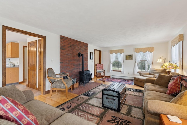 living area featuring baseboards, a baseboard radiator, wood finished floors, and a wood stove