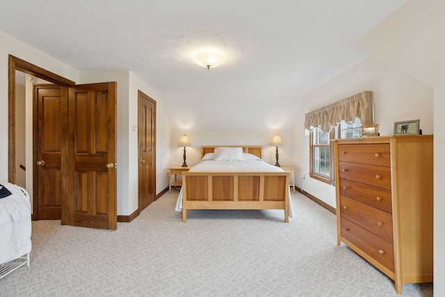 bedroom featuring baseboards, vaulted ceiling, and light colored carpet