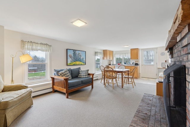 living area with a fireplace, baseboard heating, and carpet flooring