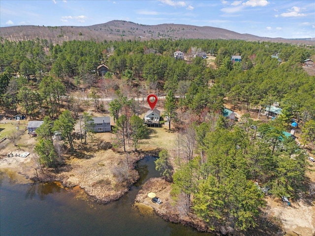 aerial view with a water and mountain view and a wooded view