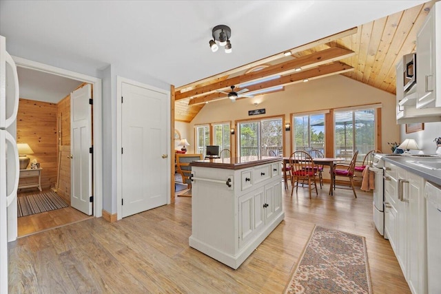 kitchen with ceiling fan, white cabinets, vaulted ceiling with beams, white appliances, and light wood-style flooring