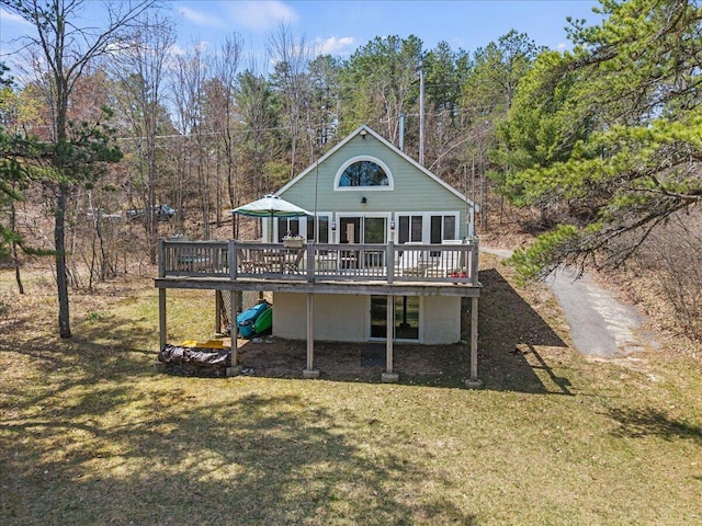 back of house with a yard, a forest view, and a wooden deck