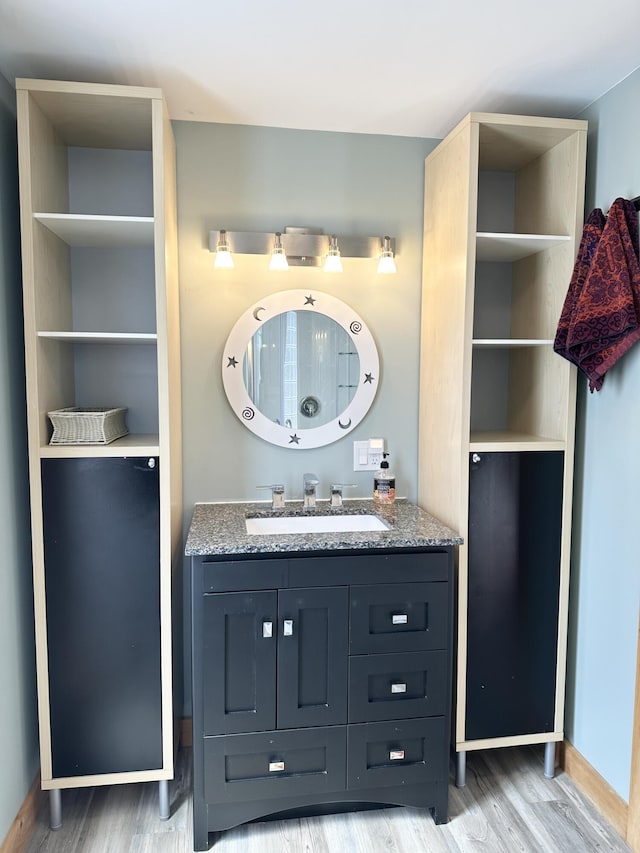 bathroom featuring baseboards, wood finished floors, and vanity